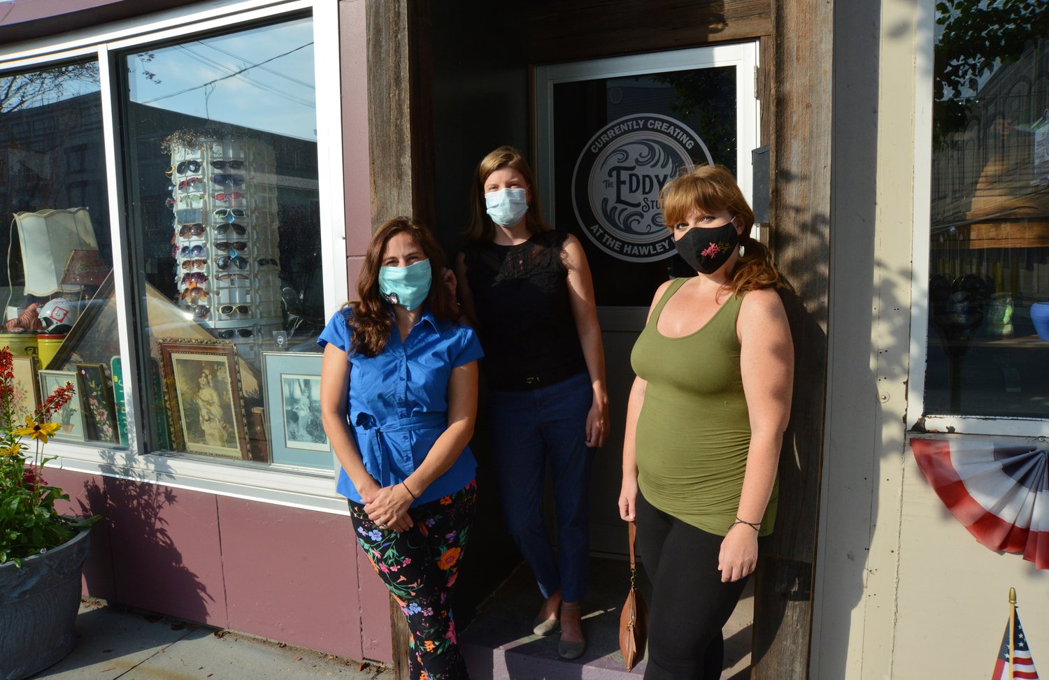 Alison Hoffmann, left, Sarah Clauss and Jill Carletti stand in front of the historic Murray building on Main Avenue in Hawley, now home to their creation: the Hawley Hub.